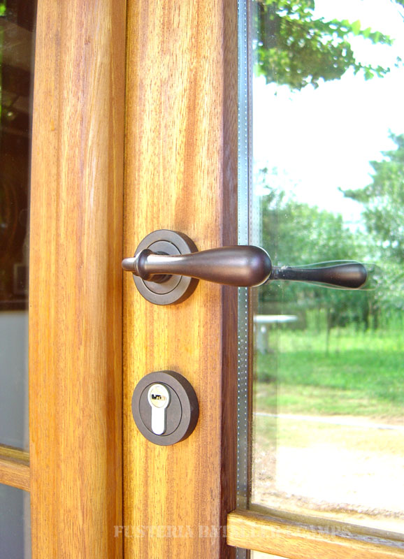 Porta exterior amb porticons i vidriera Iroko detall tirador