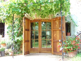 Porta exterior amb porticons i vidriera Iroko oberta